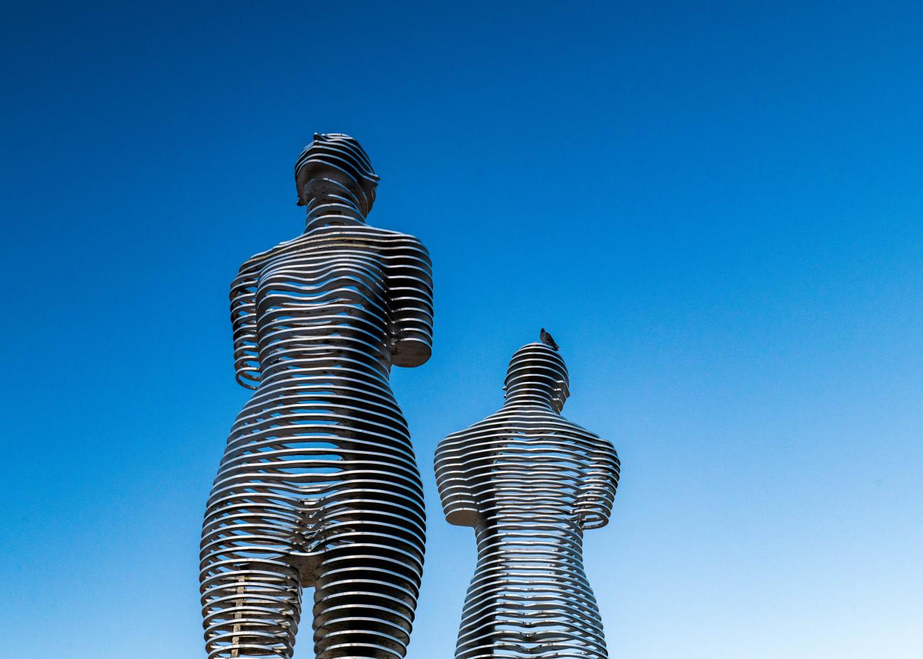 The Ali and Nino moving metal sculpture in Batumi silhouetted against a clear blue sky.