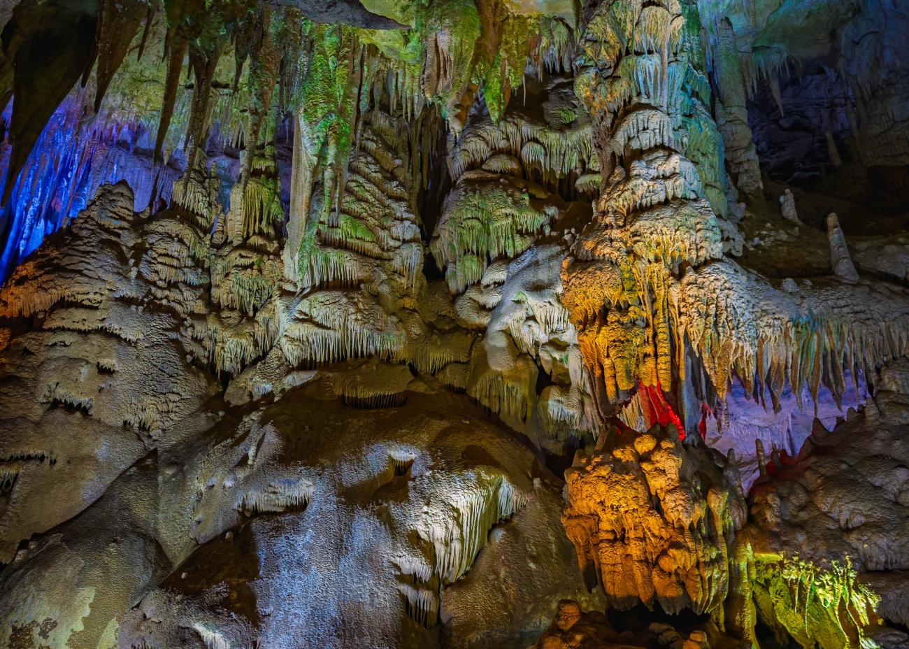 Illuminated stalactites and stalagmites inside Prometheus Cave near Kutaisi, Georgia.
