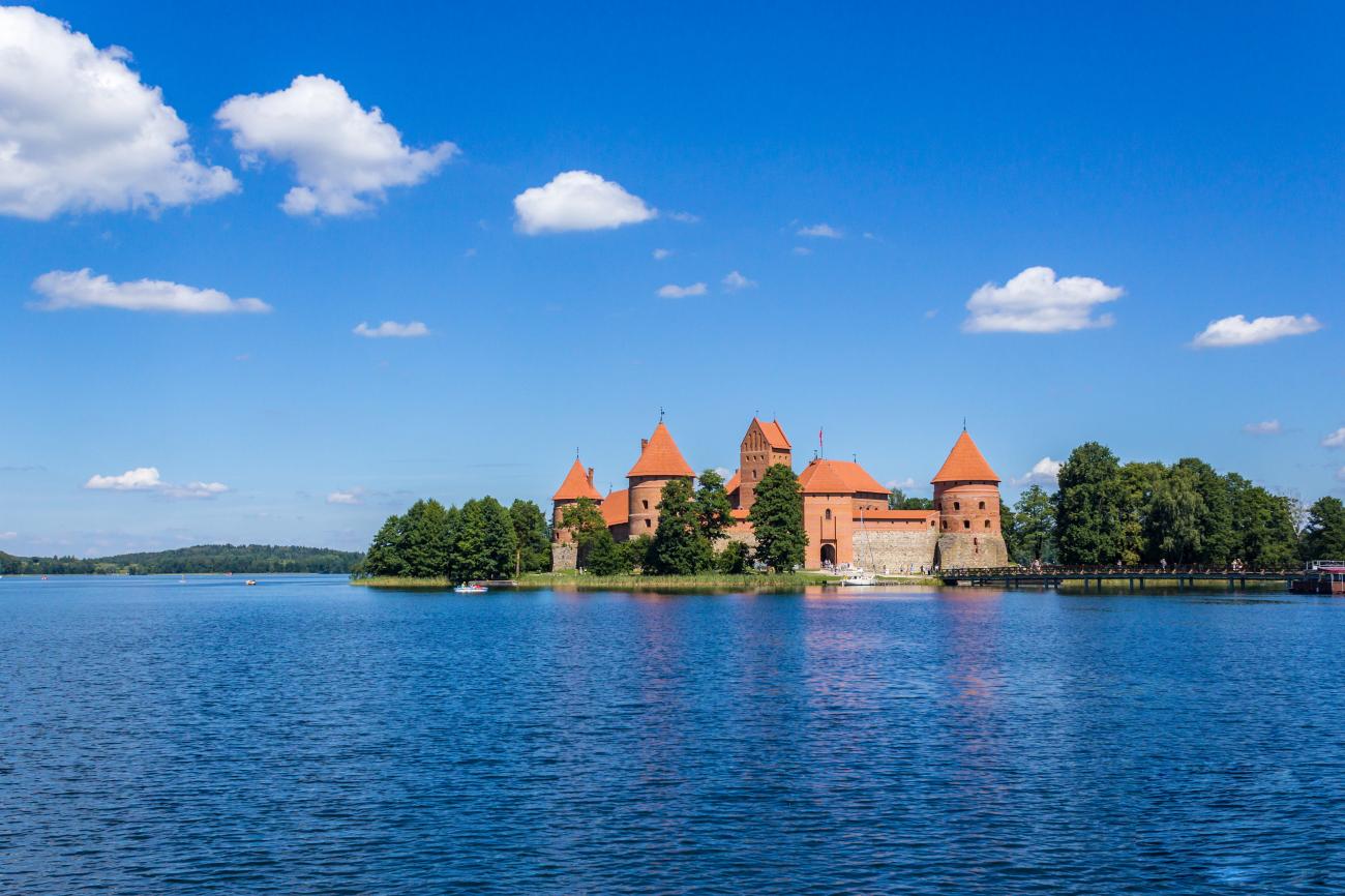 Trakai Island Castle surrounded by blue lake water under a clear sky in Lithuania.