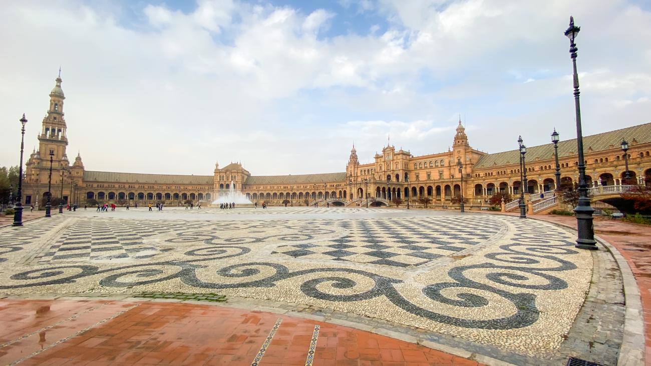 Panoramic view of the semicircular Plaza de Espana in Seville with its ornate mosaic-tiled forecourt.